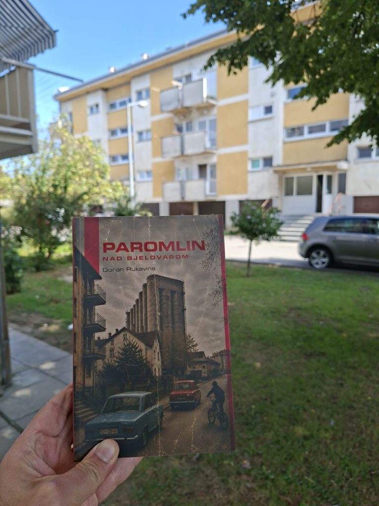 Knjiga Paromlin nad Bjelovarom Gorana Rukavine ispred stambene zgrade u Bjelovaru